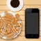 Mobile phone and Christmas gingerbread with coffee cup on wooden table