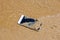 The Mobile phone fall to the sea water on the sandy beach