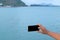 Mobile phone in hand with sea