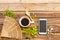 Mobile phone ,hot coffee ,wooden fan and flowers ,leaf arrangement flat lay style