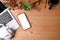 Mobile phone, laptop, pencil holder, coffee cup and headphone on wooden background.