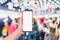 Mobile phone mockup image, hand holding blank screen mobile smart phone with blurred  Crowd of people in the shopping store,