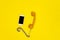 Mobile phone and old fashioned handset on yellow background.
