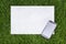 Mobile phone and sheet of paper on the grass