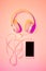 Mobile phone smartphone and headphones on pink