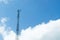 Mobile phone transmitter pole on blue sky and clouds