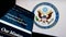 Mobile phone with website of United States Department of State (DOS) on screen in front of seal.