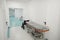 Mobile postoperative bed and a wheelchair stand in hospital corridor