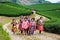 Moc Chau, Vietnam - November 4, 2017: Mountain spring scenery with blossoming plum tree, Hmong little girls carrying cabbage flowe