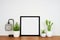 Mock up black square frame with home decor and potted plants wih wood shelf and whitewall