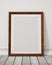 Mock up blank wooden picture frame on the wall and the floor