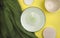 Mock up composition with empty ceramic tableware, green fabric on yellow background.