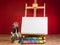 Mock up easel palette watercolors and brushes with empty white canvas