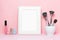 Mock up frame and nail polishes with make up brushes and accessorises women`s table with pink background