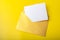 Mock-up letter or postcard with a gold envelope on a yellow background.
