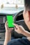 Mock up of man using mobile smart phone inside a car. Driver hand holding blank green screen smartphone, searching address and pin