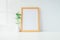 Mock up portrait photo frame with green plant on table, home dec