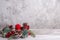 Mock-up of red Christmas candle and a wreath of Christmas tree branches, cones, red berries on a wooden table