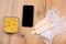 Mock up screen smartphone near depilation waxing set: spatula, medical gloves and pearl wax granules on wooden table background.