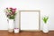 Mock up square wood frame with vases of cut flowers and succulent plant on a wood shelf