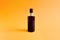 Mock-up of unbranded brown plastic spray bottle on a textured bright orange background. Cosmetic bottle container for branding