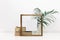 Mock up wooden frame with green tropical leaves.