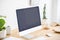 Mockup of black desktop computer screen on wooden desk in natura