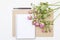 Mockup with blank notepad and little garden pink roses. Workspace.