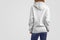 Mockup clothes series. Gracile beaty woman in a white hoodie and blue pants  on the blank studio backgrounds