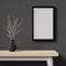 Mockup of a cozy room with dark wall, wooden table, empty picture frame and a vase, 3d rendering. Template and background of a