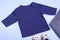 Mockup for design and placement of logos, advertising. Blue children`s raglan, polo, blouse top view, mockup on a blue background