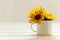 Mockup with enamel cup and sunflowers. Empty white cup with space for text, print or pattern. White background