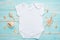 Mockup Flat Lay White Baby Bodysuit Shirt on a Blue Rustic Wood Background with Nautical Seashell, Seashells and the Sea