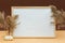 Mockup frames on a brown background, fluffy branches of dried flowers and white berries. Autumn still life. Background