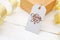 Mockup gift and blank tag with calligraphic text Thank you on white wooden background with gold ribbon. Lettering