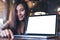 Mockup image of an Asian business woman presenting and showing laptop with blank white screen on wooden table