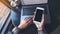 Mockup image of business woman holding mobile phone with blank black screen while using laptop on table