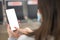 Mockup image of female hands holding black mobile phone with blank white screen over flight board in airport terminal. Woman Using