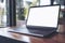 Mockup image of laptop with blank white screen on wooden table near by window