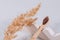 Mockup image, trendy still life composition with natural bamboo toothbrush and dried flowers on wavy plaster mold