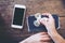 Mockup image of white mobile phone with blank black screen and playing fidget spinner on vintage wooden table