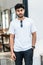 Mockup image of a young bearded man doing a pose while wearing white blank shirt