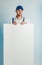 Mockup image of a young indignant worker holding empty white banner. White or blue background. Bussines concept