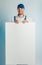 Mockup image of a young smilling worker holding empty white banner. White or blue background. Bussines concept