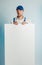 Mockup image of a young surprised worker holding empty white banner. White or blue background. Bussines concept