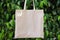 Mockup Linen Cotton Tote Bag on Green Forest Trees Foliage Background. Eco Nature Friendly. Environmental Conservation Recycling