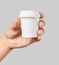 Mockup of men`s hand holding white paper espresso cup with white cover