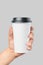 Mockup of men`s hand holding white paper large size cup with black cover