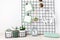 Mockup of mesh board with blank cardsm sunglasses, earphones, house plants, alarm clock. Stay home, home organisation idea