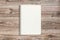 Mockup of open notepad with blank page on wooden background.